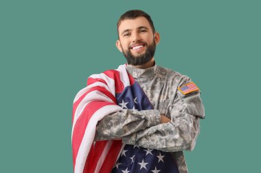 Yeşil arka planda Amerikan bayrağı taşıyan erkek asker