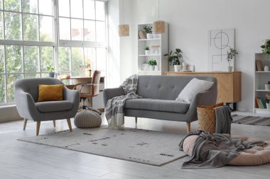 Koltuğu, koltuğu ve işyeri olan aydınlık oturma odasının içinde.