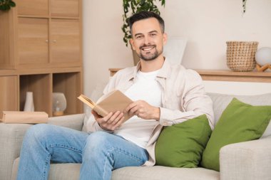 yakışıklı adam evde kanepede kitap okuma