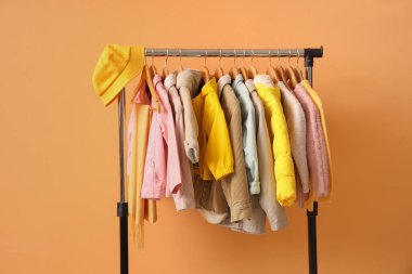 Süslü çocuk kıyafetleri ve turuncu arka planda aksesuarlarla doldur.