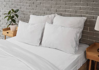 Modern yatak odasında battaniyeli beyaz yastıklar.