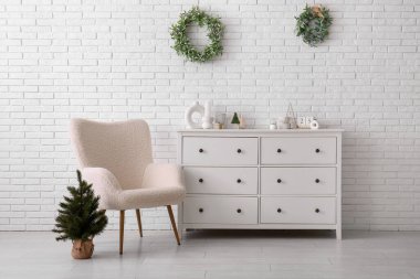 Oturma odasının içinde koltuk, tuvalet ve Noel ağacı var.