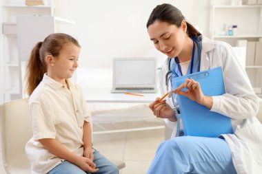 İşitme cihazlı küçük kız kliniği ziyaret ediyor.