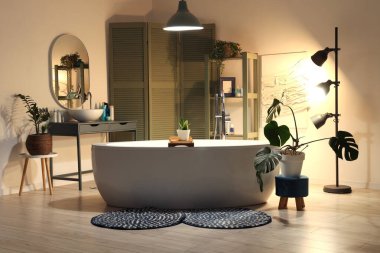 Banyonun içinde küvet, yeşil katlanan ekran ve akşamları parlayan lambalar.