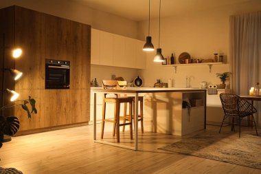 Akşamları masaları, tezgahları ve parlayan lambaları olan modern mutfağın içi.