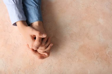 Bej rengi grunge arka planda el ele tutuşan çift, üst görünüm