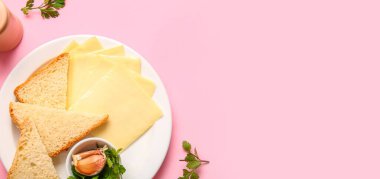 Pembe zemin üzerinde lezzetli işlenmiş peynir ve ekmek tabağı ve metin için boşluk