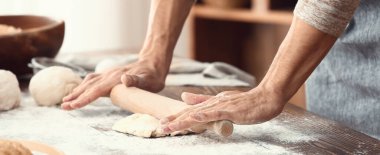 Adam mutfakta ekmek hazırlıyor.