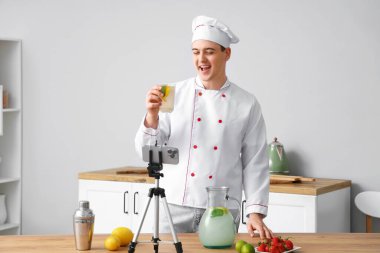 Erkek şef onun mutfakta ev yapımı limonata yaparken videosunu kaydediyor.