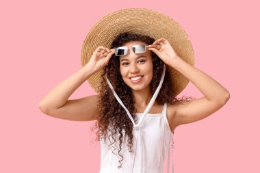 Beautiful African-American woman with sunglasses on pink background clipart