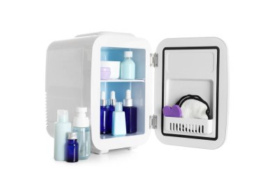 Beyaz arka planda kozmetik ürünleri olan küçük bir kozmetik buzdolabı