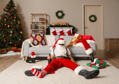Şişeyle sarhoş Noel Baba partiden sonra yerde uyuyor.