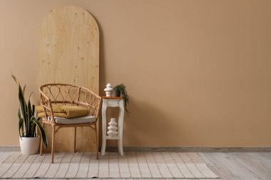 Oturma odasının içinde bej halı, koltuk ve masa var.