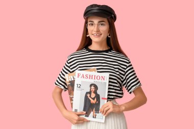 Diastema ve pembe arka planda dergileri olan şık genç bir kadın.