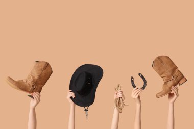 Arka planda kovboy aksesuarları olan kadın eller.