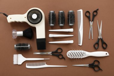 Kahverengi arka planda farklı kuaför aksesuarları.