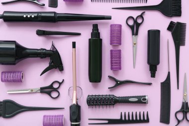Pembe arka planda farklı kuaför aksesuarları.