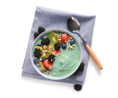 Beyaz arka planda lezzetli spirulina smoothie ile peçete ve kase