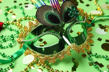 Yeşil arka planda dekor olan güzel bir karnaval maskesi. Yakın çekim.