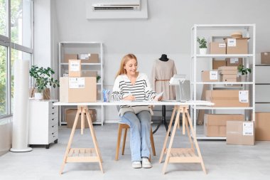 Çevrimiçi mağaza deposunda çalışan kadın satıcı.