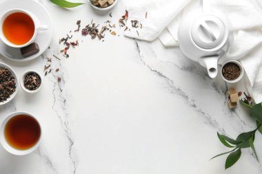 Süslü çaydanlıktan yapılmış çerçeve, mermer arka planda bir fincan çay ve peçete.