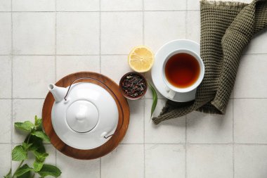 Çay demliği, çay fincanı, limon ve peçeteyle harika bir kompozisyon.