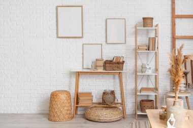 Boş çerçeveleri, masası ve kitaplığı olan oturma odasının içi