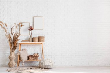 Odanın içinde masa, otlar ve boş çerçeveler var.