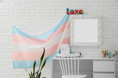 Masası, aynası ve transseksüel bayrağı olan makyaj odasının içi