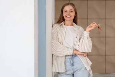 Anahtarları olan güzel genç bir kadın evinin kapısında bekliyor.