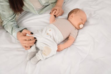 Anne, tatlı, küçük, uyuyan bir bebekle evde yatıyor, yakın plan.