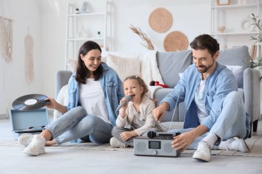 Mikrofonu ve radyo sistemi olan mutlu bir aile evde karaoke yapıyor.