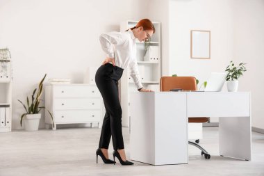 Ofiste sırt ağrısı çeken genç ve güzel bir iş kadını.