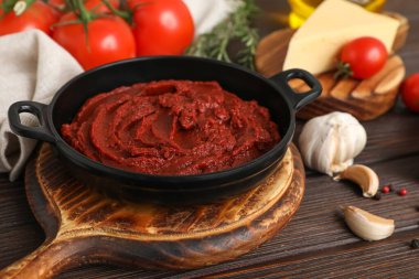 Koyu ahşap arka planda domates ezmeli tava, yakın plan.