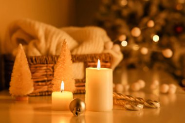 Odadaki Noel ağacına karşı yanan mumlar ve güzel dekorasyonlar.