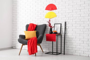 Çin Yeni Yılı için dekore edilmiş oturma odasının içinde koltuk ve masa var.