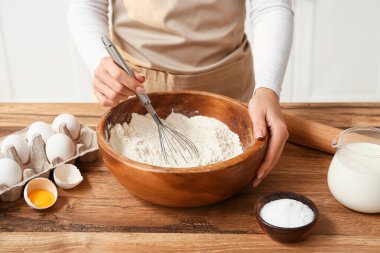 Kadın mutfak tezgahında hamur hazırlıyor.