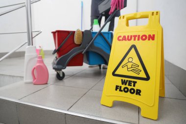 Merdivenlerde temizlik malzemeleriyle dolu tramvayla kadın hademelere karşı uyarı levhası.