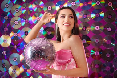 Disklere karşı disko topuyla şık genç bir kadın.
