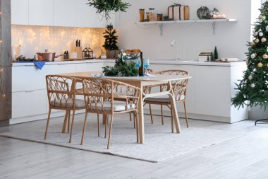 Modern mutfak, şenlikli masa dekorasyonu, parıldayan ışıklar ve Noel süslemeleri.