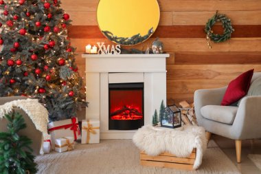 Noel ağacı, şömine ve koltuğu olan şenlikli bir oturma odası.