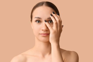 Kahverengi arka planda güzel kaşları olan genç bir kadın.