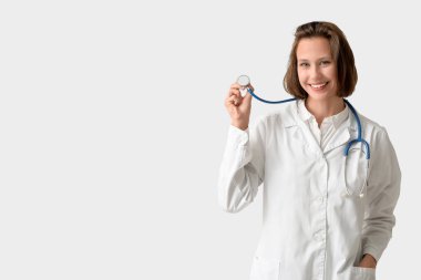 Beyaz arka planda steteskobu olan mutlu bir kadın doktor.