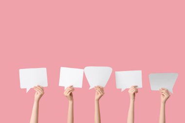 Pembe arka planda konuşma baloncukları olan kadın eller