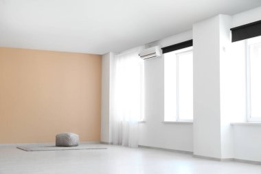 Pouf ve halı şık boş bir odada.