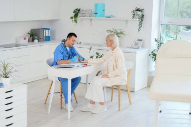 Kan şekerini ölçen tükenmez kalemli erkek endokrinolojist klinikteki kadın hasta.