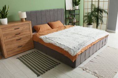 Şık modern yatak odası, temiz yatak odası, raf ünitesi ve ev bitkileri.