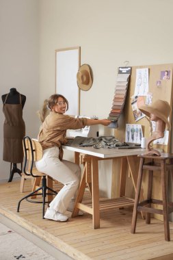 Atölyesinde çalışan genç bayan terzi.