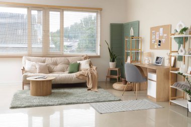 Beyaz kanepesi, sehpası, çalışma alanı ve ruh hali tahtası olan şık bir oturma odası.