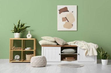 Yumuşak yastıklı ve dolabında battaniyesi olan şık bir oturma odası.